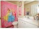 Bright bathroom featuring a vanity and a pink princess-themed shower curtain at 50989 Highway 27 # 176177, Davenport, FL 33897