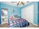 Blue bedroom featuring a ceiling fan, closet, and colorful bedding at 50989 Highway 27 # 176177, Davenport, FL 33897