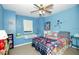 Cozy blue bedroom with a ceiling fan, window seat, and colorful bedding at 50989 Highway 27 # 176177, Davenport, FL 33897
