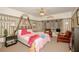Bedroom with ceiling fan, patterned wallpaper, and upholstered seating area at 50989 Highway 27 # 176177, Davenport, FL 33897