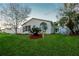 Home with well-maintained lawn, nice landscaping, and view of an outdoor screened-in porch at 50989 Highway 27 # 176177, Davenport, FL 33897
