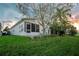 Cozy home featuring mature trees, green grass, and a charming screened-in porch for relaxing outdoors at 50989 Highway 27 # 176177, Davenport, FL 33897