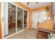 Bright sunroom featuring wood paneled walls, ceiling fan, and sliding glass doors at 50989 Highway 27 # 176177, Davenport, FL 33897