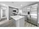 Spacious kitchen with stainless steel appliances, gray cabinets, center island, and wood grain floors at 514 S Cottage Hill Rd, Orlando, FL 32805