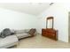 Cozy bedroom with a gray sectional sofa, dresser with mirror, and tiled floors at 519 Beasley Ct, Orlando, FL 32807