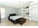 Cozy bedroom featuring striped walls, tan flooring, and neutral-toned decor with an ottoman at 519 Beasley Ct, Orlando, FL 32807