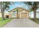 Tan single Gathering home featuring a palm tree, a 1-car garage, and a concrete driveway at 519 Beasley Ct, Orlando, FL 32807