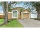Tan single Gathering home featuring a palm tree, a 1-car garage, and a concrete driveway at 519 Beasley Ct, Orlando, FL 32807