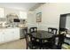 Kitchen area featuring white cabinets, stainless steel appliances, and a black dining table with chairs at 519 Beasley Ct, Orlando, FL 32807