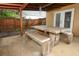 Covered patio area with rustic wood table and bench seating adjacent to lush backyard at 519 Beasley Ct, Orlando, FL 32807