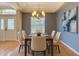Formal dining room showcases a modern chandelier, tray ceiling, and a large window for natural light at 5311 Saddleback Ct, Lady Lake, FL 32159