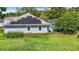 Home exterior features solar panels, a serene backyard, and an inviting screened-in pool at 5311 Saddleback Ct, Lady Lake, FL 32159