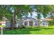 Charming single-Gathering home featuring lush landscaping, a manicured lawn, and solar panels on the roof at 5311 Saddleback Ct, Lady Lake, FL 32159