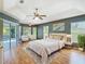 Spacious bedroom with tray ceilings, an ensuite bathroom, and sliding glass doors to outdoor living at 5311 Saddleback Ct, Lady Lake, FL 32159