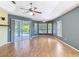 Spacious main bedroom with wood floors, ceiling fan, and sliding doors leading to the outdoor patio area at 5311 Saddleback Ct, Lady Lake, FL 32159