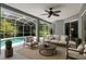 Screened-in patio boasts outdoor seating, ceiling fan, and a view of the inviting in-ground pool at 5311 Saddleback Ct, Lady Lake, FL 32159