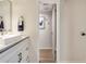 Bathroom showcasing a white vanity with modern sink and a glimpse into the hallway beyond at 563 Midway Trak # K102, Ocala, FL 34472