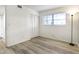 This bedroom features wood flooring, a window, neutral walls, closet, and a modern light fixture at 563 Midway Trak # K102, Ocala, FL 34472