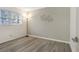 This bedroom features wood flooring, a window, neutral walls, and a modern light fixture at 563 Midway Trak # K102, Ocala, FL 34472