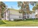 Exterior of the apartment building with a well-manicured lawn and mature trees at 563 Midway Trak # K102, Ocala, FL 34472