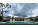 Community pool is open for a swim, flanked by a shady clubhouse and palm trees at 6108 Curry Ford Rd # 116, Orlando, FL 32822