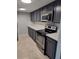 Kitchen featuring stainless steel appliances, tiled flooring, and painted cabinetry at 6108 Curry Ford Rd # 116, Orlando, FL 32822
