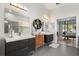 Elegant bathroom features dual sinks with dark vanities, stylish lighting, and modern gray tile floors at 6426 Montclair Bluff Ln, Windermere, FL 34786