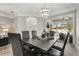 Dining area featuring a dark wood table, modern chandelier, and sliding glass doors leading to the outdoor pool area at 6426 Montclair Bluff Ln, Windermere, FL 34786