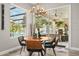 Cozy dining area with a round table, modern chandelier, and view of the outdoor patio and pool area at 6426 Montclair Bluff Ln, Windermere, FL 34786