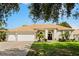 Charming one-story home featuring a well-manicured lawn, beautiful landscaping, and a double-door entrance at 6426 Montclair Bluff Ln, Windermere, FL 34786