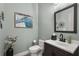 Stylish powder room with a modern vanity, mirror, and decorative artwork at 6426 Montclair Bluff Ln, Windermere, FL 34786