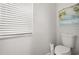 Clean and simple toilet room with a standard toilet, white walls, and a window for natural light at 6426 Montclair Bluff Ln, Windermere, FL 34786