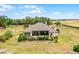 Expansive aerial view of a house with a pool, bordered by lush greenery and an open field at 9019 Tower Pine Dr, Winter Garden, FL 34787