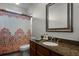 Well-lit bathroom featuring a granite countertop and colorful patterned shower curtain at 9019 Tower Pine Dr, Winter Garden, FL 34787