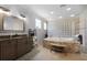 Elegant bathroom with whirlpool tub, gray vanity, and glass block window at 9019 Tower Pine Dr, Winter Garden, FL 34787