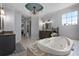 Spacious bathroom featuring tiled tub, vanity with dark cabinets, and large mirror at 9019 Tower Pine Dr, Winter Garden, FL 34787