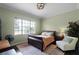 Comfortable bedroom with a large window, wooden floors, and an inviting chair at 9019 Tower Pine Dr, Winter Garden, FL 34787