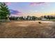 Spacious equestrian arena under a beautiful sunset, offering a serene training environment at 9019 Tower Pine Dr, Winter Garden, FL 34787