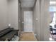 Hallway leading to dining area with storage shelves, dark door, and tile floor at 9019 Tower Pine Dr, Winter Garden, FL 34787