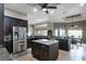 A chef's kitchen featuring dark wood cabinets, granite counters, a center island, and stainless steel appliances at 9019 Tower Pine Dr, Winter Garden, FL 34787