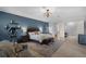 Large bedroom featuring blue accent wall, exercise bike, and neutral decor at 9019 Tower Pine Dr, Winter Garden, FL 34787