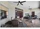 Outdoor patio with stone facade, dining area, grill, and comfortable seating beneath ceiling fans at 9019 Tower Pine Dr, Winter Garden, FL 34787
