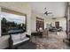 Outdoor patio with stone facade, dining area, grill, and comfortable seating beneath ceiling fans at 9019 Tower Pine Dr, Winter Garden, FL 34787