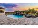 Backyard pool with rock waterfall feature, spa, and patio, set against a colorful sky at 9019 Tower Pine Dr, Winter Garden, FL 34787