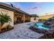 Backyard pool with rock waterfall feature and spacious patio, viewed from the side of the house at 9019 Tower Pine Dr, Winter Garden, FL 34787