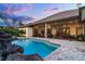 Backyard pool with rock waterfall feature and spacious patio, viewed from the side of the house at 9019 Tower Pine Dr, Winter Garden, FL 34787
