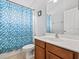 Bathroom featuring a blue mosaic shower curtain, a white sink, and a wooden vanity at 903 Tramells Trl, Kissimmee, FL 34744