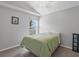 Cozy bedroom with carpet flooring, light gray walls, and a comfortable bed with a green comforter at 903 Tramells Trl, Kissimmee, FL 34744