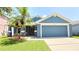 Inviting single-story blue home with a well-manicured lawn and a two-car garage at 903 Tramells Trl, Kissimmee, FL 34744