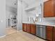 Open kitchen with stainless steel dishwasher, wood cabinets, and bright countertop space at 903 Tramells Trl, Kissimmee, FL 34744